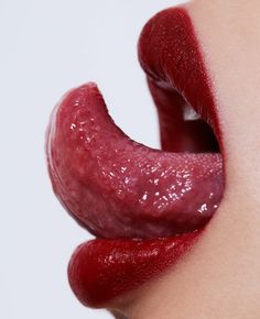 a woman's lips are covered in red lipstick and the lip is shaped like a mouth