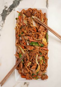 stir fry noodles with meat and vegetables on a plate