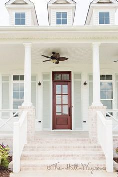 a white house with a red door and ceiling fan