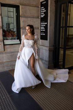 a woman in a white wedding dress is standing on the sidewalk with her legs spread out