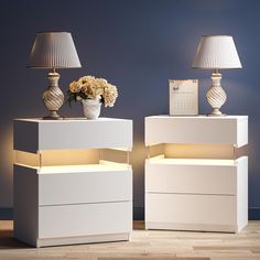 two white nightstands with lamps and flowers on them