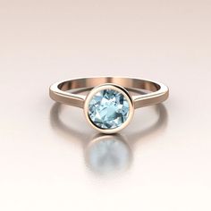 14K Rose Gold modern engagement ring. This ring has a delicate cathedral shank and bezel set round Aquamarine. The center stone is 6mm (total weight around 1ct, color may vary due to the nature of this stone) bezel set. There is nothing better for the modern bride! Simple, elegant and beautiful.We only work with environment friendly precious metals and conflict free stones. All our jewelry is made in SOLID gold, no gold-filled or gold plated jewelry. The process we use to fabricate our jewelry i Modern 14k Gold Topaz Ring With Bezel Setting, Modern 14k Gold Bezel Set Topaz Ring, Modern Round Cut Birthstone Ring With Bezel Setting, Modern Birthstone Ring With Bezel Setting, Modern Round Birthstone Ring With Tension Setting, Modern Bezel Set Birthstone Promise Ring, Rose Gold Rings With Bezel Setting, Modern Birthstone Ring With Bezel Setting For Promise, Fine Jewelry Round Birthstone Ring With Bezel Setting