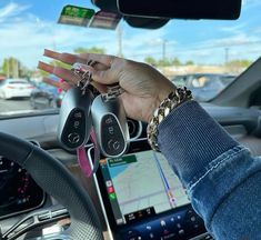 a person holding two car keys in their hand while sitting in the driver's seat