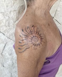 an older woman with a tattoo on her shoulder