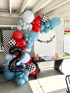 balloons are arranged in the shape of numbers and checkered squares on display at a race themed birthday party