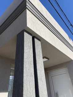 the corner of a building with two columns on each side and power lines in the background