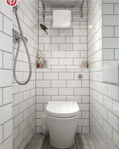 a white toilet sitting in a bathroom next to a shower