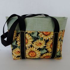 "Sunflower fabric tote bag features a bucket styling with 6 outside pocket areas and a generous inside space. This handy tote can be used as a summer handbag or as an organizer bag for any take along projects ie: knitting or crochet projects, books, readers or tablets. Straps are long enough for a shoulder carry. Bag is sturdy fabric construction, fully lined and interfaced to give the bag good body. Measurements of this bag are: 11\" X 8\" X 4\" . Outside pockets are 6\" deep, 2 center pockets Yellow Fabric Tote Bags, Yellow Fabric Everyday Bag, Yellow Fabric Rectangular Bag, Yellow Rectangular Fabric Bag, Fabric Bags With Pockets For Daily Use, Fabric Tote Bags With Pockets, Fabric Tote Shoulder Bag With Zipper Pocket, Tote Bags With Pockets As Gifts, Green Fabric Tote Bag