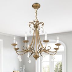 a chandelier hanging from the ceiling in a room with white walls and windows