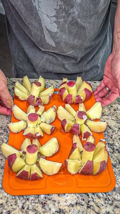 a person is cutting up some food on an orange tray