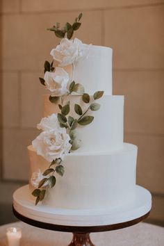 a wedding cake with white flowers and greenery