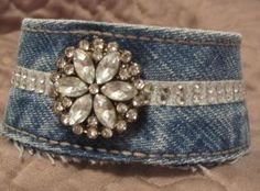 a blue jean cuff with a crystal flower on it