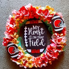 a football wreath with flowers around it that says, my heart is on that field