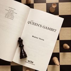 an open book with a chess piece on it