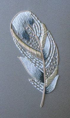 a close up of a piece of cloth with a metal leaf on it's side