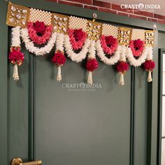 red and white flowers are hanging from the side of a door with tassels