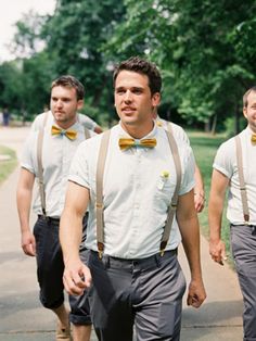 three men wearing suspenders and bow ties walking down the street