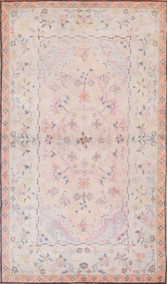 an antique rug with floral designs and fringes on the edges, in pastel colors