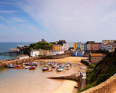 boats are parked on the beach in front of some buildings