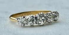 three stone diamond ring in yellow gold and white gold with diamonds on the sides,