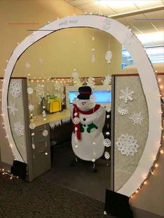 an office cubicle decorated with snowmen and christmas lights