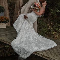 a bride and groom kissing on a dock