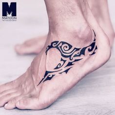 a man's foot with an intricate tattoo design on the top of his leg