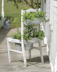 an old chair is filled with plants on the front porch, and has been turned into a planter