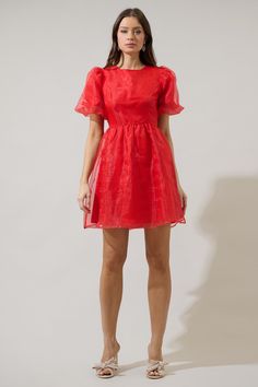 If you like to be trendy, you need Borza Organza Mini Dress! It’s such an adorable dress that has angled, ruffled short sleeves. The back side has an invisible zipper closure followed by a big bow tie back detail. Bodice has a relaxed fit and has a flowy skirt with an organza fabric all over this dress. It will look cuter with heels and your favorite jewelry pieces. - Lined- Puffed short sleeves- Bow details- Zipper back- Comes in 2 colorsSize + Fit - Model is 5'10" and wearing size XS- Measurem A-line Puff Sleeve Dress With Ruffles For Party, Summer Evening A-line Short Sleeve Dress, Spring Fitted Puff Sleeve Dress With Bow, Flirty Mini Dress With Tie Back And Short Sleeves, Summer Party Mini Dress With Flutter Sleeves, Flutter Sleeve Mini Dress For Party, Puff Sleeve Mini Dress With Bow For Party, Knee-length Short Sleeve Dress For Summer Evening, Party Puff Sleeve Dress With Tie Back