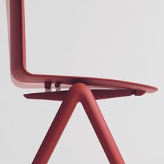 a red chair sitting on top of a white floor