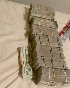 stacks of money sitting on top of a bed