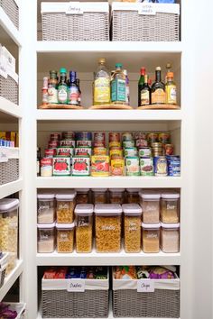 an organized pantry with lots of food in baskets on the bottom shelf and shelves full of condiments