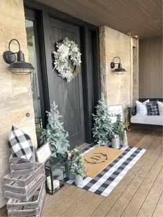 the front porch is decorated for christmas with wreaths and potted trees on it