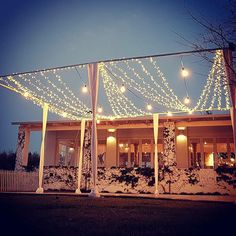 a house covered in christmas lights and decorated with garlands on the front porch is lit up at night