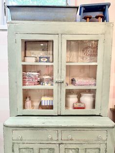 an old china cabinet with glass doors and drawers