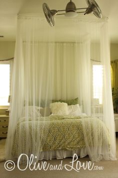 a canopy bed with two lamps hanging from it's headboard in a bedroom