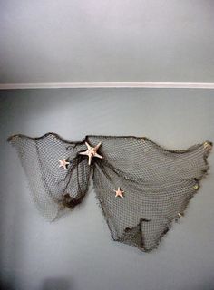 there is a net hanging on the wall with three stars attached to it, and one star has been cut out