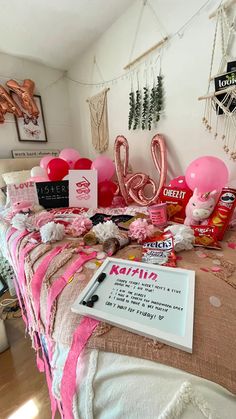 a bed with pink and white decorations on top of it next to a sign that says love