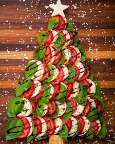 a christmas tree made out of tomatoes, mozzarella cheese and spinach leaves