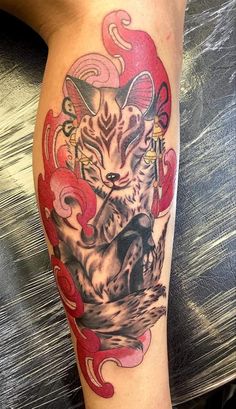 a woman's leg with a tattoo on it that has an image of a cat