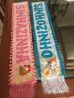 two decorated banners sitting on top of a wooden table