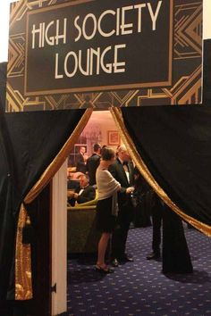 the entrance to high society lounge is decorated with gold and black fabric, while people stand in line