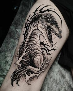 a man's arm with a black and white tattoo design on it, featuring an image of a dinosaur