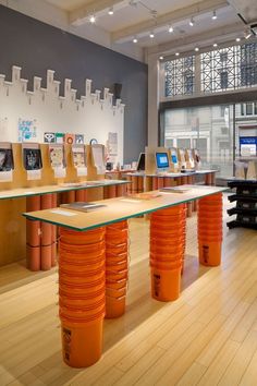 there are many orange vases on display in the room with wooden floors and walls