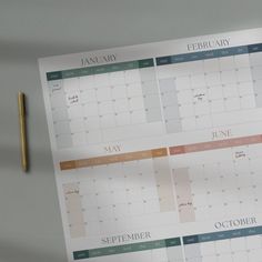 two calendars are sitting on top of each other next to a pen and pencil