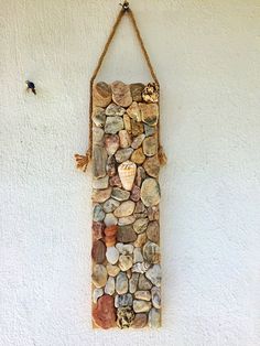 a stone wall hanging on the side of a building with rocks and shells embedded in it