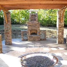 an outdoor fireplace and grill in the middle of a patio