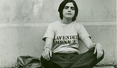 black and white photograph of a woman sitting on the ground in front of a wall