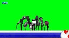 a bunch of microphones sitting in front of a green screen with the world on it