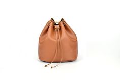 "This is a simple and entirely full-grain leather bucket bag / carry on bag with leather drawstring closure. This is the perfect gift for her! You will love this shoulder bag, because it has plenty of space for your everyday essentials, books, small laptop or tablet. It is an understatement design bucket bag for any outing. The hard-wearing and adjustable strap allows you to wear it as a shoulder bag or a crossbody. Includes a small leather locking mechanism for tightening. It is entirely made f Brown Smooth Grain Bucket Hobo Bag, Leather Drawstring Bag With Adjustable Strap For Travel, Leather Lined Bucket Bag For Shopping, Leather-lined Bucket Bag For Shopping, Brown Smooth Grain Bucket Bag, Leather Bucket Shoulder Bag Gift, Leather Bucket Shape Shoulder Bag For Gift, Leather Bucket Shape Shoulder Bag As Gift, Leather Bucket Bag With Dust Bag As Gift